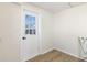 Bright laundry room with white door and wood-look floors at 305 Hamilton St, Fortville, IN 46040