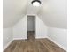 Finished attic space with hardwood flooring and a glimpse into an adjacent room at 3102 N Arsenal Ave, Indianapolis, IN 46218