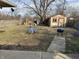 Large backyard with shed, wood fence, grass and concrete sidewalk leading to a grill at 4119 N Butler Ave, Indianapolis, IN 46226