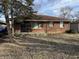 Charming brick home featuring a cozy porch and well-maintained front yard with mature tree at 4119 N Butler Ave, Indianapolis, IN 46226