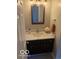 Bathroom features a dark wood vanity with a white countertop and a decorative mirror at 6639 N College Ave, Indianapolis, IN 46220