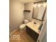 Half bath with gray walls, vanity and mirror, shelf and toilet at 6639 N College Ave, Indianapolis, IN 46220
