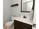 Small bathroom with dark brown vanity, white sink, and toilet at 6639 N College Ave, Indianapolis, IN 46220