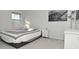 Bright bedroom with a queen bed, gray carpet, and a large window at 6639 N College Ave, Indianapolis, IN 46220