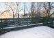 Small snow covered deck with green railing and woodland view at 6639 N College Ave, Indianapolis, IN 46220
