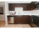 Kitchen with dark cabinets, stainless steel appliances, and light countertops at 6639 N College Ave, Indianapolis, IN 46220