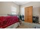 Bedroom with wooden bed frame, armoire, and window at 7842 Cork Bend Ln, Indianapolis, IN 46239
