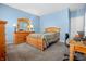 Light blue bedroom with wooden bed frame and work desk at 7842 Cork Bend Ln, Indianapolis, IN 46239