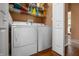 Bright laundry room, washer, dryer, and shelving for storage at 7842 Cork Bend Ln, Indianapolis, IN 46239