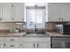 Kitchen features white cabinets, granite counters, a double sink and microwave at 956 Dorchester Dr, Noblesville, IN 46062