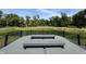 Scenic deck with pond view, featuring gray composite decking, a black metal railing, and two matching gray benches at 9893 Greenvine Dr, Carmel, IN 46032