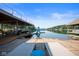 Backyard view featuring a dock, boat slip with slide, and patio with lounge chairs overlooking the serene lake at 10841 W Grandview Dr, Columbus, IN 47201