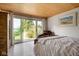 Bedroom with wood ceiling and patio access, offering serene lake views at 10841 W Grandview Dr, Columbus, IN 47201