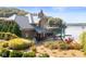 Beautiful waterfront home featuring a stone chimney, metal roof, patio, and private dock at 10841 W Grandview Dr, Columbus, IN 47201