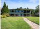 Stunning lake house featuring expansive windows, red lounge chairs, and a lush green lawn at 10841 W Grandview Dr, Columbus, IN 47201