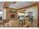 Warm living room with a stone fireplace, exposed beams, and hardwood flooring at 10841 W Grandview Dr, Columbus, IN 47201