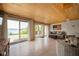 Bright living room with wood ceiling, water view, and multiple sliding glass doors to the patio at 10841 W Grandview Dr, Columbus, IN 47201