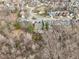 Drone shot of the home, showing the backyard layout and its surroundings of trees and street at 10842 Belmont Cir, Indianapolis, IN 46280