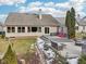 Spacious backyard featuring a gray deck, stone patio with seating, and landscaped greenery with patches of snow at 10842 Belmont Cir, Indianapolis, IN 46280