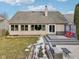 Backyard view showcasing a gray deck, stone patio with seating, and landscaped greenery with patches of snow on the lawn at 10842 Belmont Cir, Indianapolis, IN 46280