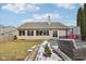 A home's backyard features a patio with wicker seating, a deck, and a lush lawn partially covered in snow at 10842 Belmont Cir, Indianapolis, IN 46280
