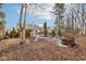 Secluded backyard with manicured landscaping, mature trees, and stone fire pit at 10842 Belmont Cir, Indianapolis, IN 46280