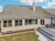 View of the back of the house with windows, gray deck and partial patio with snow on the lawn at 10842 Belmont Cir, Indianapolis, IN 46280