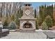 An outdoor stone fireplace with an arched opening is surrounded by lush greenery, providing an inviting outdoor ambiance at 10842 Belmont Cir, Indianapolis, IN 46280
