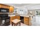 Bright kitchen with wood cabinets and black appliances with view to adjoining room at 10842 Belmont Cir, Indianapolis, IN 46280