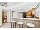 Bright kitchen featuring tile flooring, wood cabinets, breakfast bar with seating, and modern black appliances at 10842 Belmont Cir, Indianapolis, IN 46280