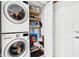 Efficient laundry area with stacked washer and dryer, plus convenient shelving for storage at 10842 Belmont Cir, Indianapolis, IN 46280