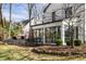 Large backyard with a sunroom addition, stone retaining wall, and mature trees offering shade and privacy at 128 Wellington Rd, Indianapolis, IN 46260