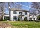 Two-story home with gray roof, black trim windows, a partial sunroom, and manicured landscaping in a lush green lawn at 128 Wellington Rd, Indianapolis, IN 46260