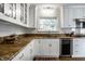 Well-lit kitchen with granite countertops, white cabinets, stainless steel dishwasher, and a cozy view at 128 Wellington Rd, Indianapolis, IN 46260