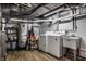 Laundry area with a washer, dryer, utility sink, water heater and storage shelves in the basement at 128 Wellington Rd, Indianapolis, IN 46260