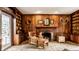 Cozy living room with wooden paneling, fireplace, built-in shelving, and comfortable seating at 128 Wellington Rd, Indianapolis, IN 46260