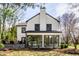 Charming two-story home featuring a light facade, brick chimney, and sunroom enclosed with large, reflective windows at 128 Wellington Rd, Indianapolis, IN 46260