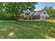 Large, grassy backyard with mature trees, a home, and an attached three car garage at 1753 Skyline Dr, Greenwood, IN 46143