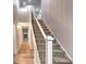 Bright hallway with hardwood floors, leading to a staircase with a decorative railing and carpeted steps at 1753 Skyline Dr, Greenwood, IN 46143