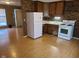Galley kitchen with white appliances and brick accent wall at 1908 Edgemont Way, Anderson, IN 46011