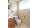 Practical bathroom with a wood vanity, toilet, mirror, and a window bringing in natural light at 310 Green St, Plainfield, IN 46168