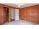 Cozy bedroom featuring classic wood paneling, neutral carpet, and a built in closet providing ample storage space at 310 Green St, Plainfield, IN 46168
