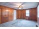Bedroom showcasing a ceiling fan, built-in storage, classic wood paneling and a window, blending character with comfort at 310 Green St, Plainfield, IN 46168