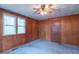 Classic bedroom features wood paneling, a ceiling fan, a window and neutral carpet, creating a warm and inviting space at 310 Green St, Plainfield, IN 46168