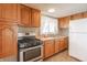 Well-lit kitchen features wood cabinetry, a stainless steel range, and double basin sink beneath the window at 310 Green St, Plainfield, IN 46168