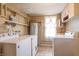 Functional laundry area with washer, dryer, storage shelves and well lit window with shelving at 310 Green St, Plainfield, IN 46168