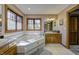 Bright bathroom featuring a large jacuzzi tub, light tile, and oak cabinets at 3101 E State Road 47, Lebanon, IN 46052