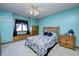 Bedroom with blue walls, wood furniture, and a ceiling fan with lighting at 3101 E State Road 47, Lebanon, IN 46052