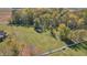 Scenic aerial view of a fenced pasture bordered by colorful fall foliage and a small shed at 3101 E State Road 47, Lebanon, IN 46052