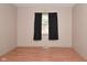 Simple bedroom with wood flooring and window with black curtains at 3301 Timberbrook Ct, Danville, IN 46122